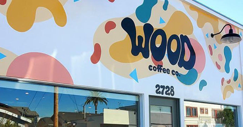 Colorful mural with 'WOOD coffee co' on a building facade